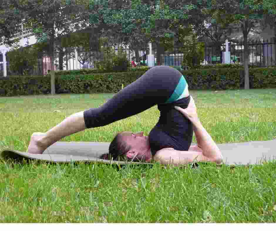 A girl doing yoga on a mat outdoors